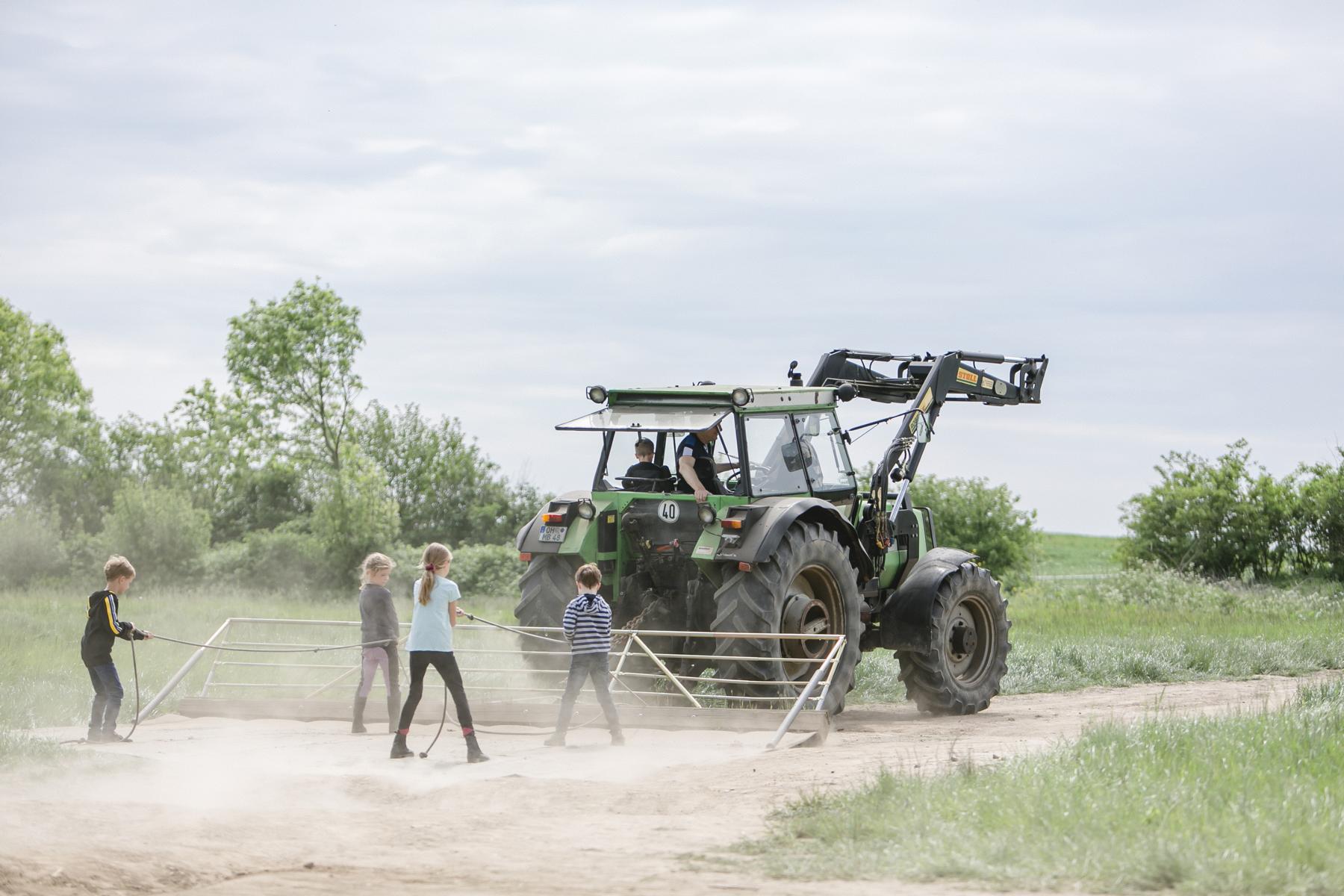 Kinder werden mit dem Traktor gezogen